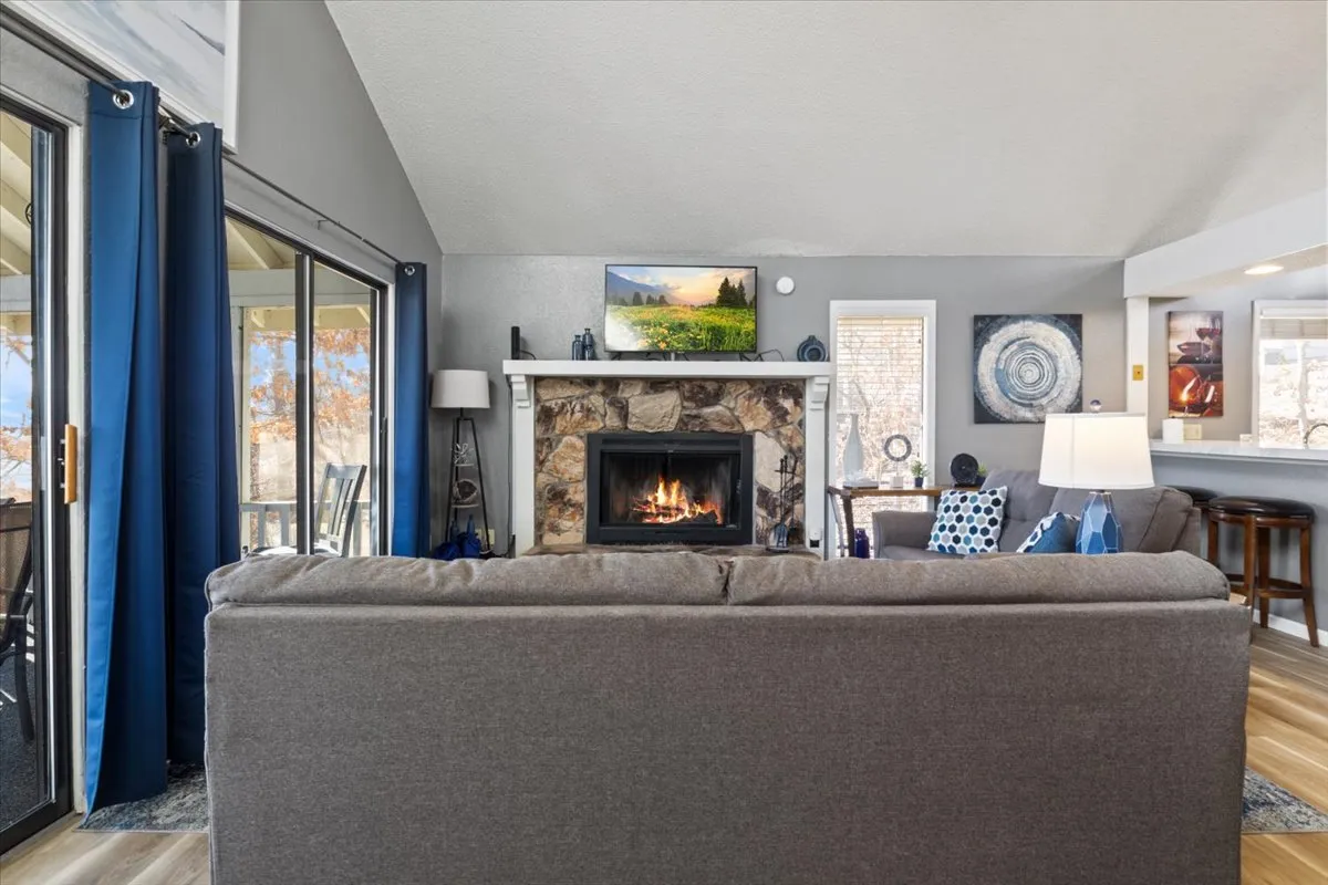 A welcoming living room featuring a cozy fireplace, plush sofa, television, and tasteful artwork. The setting is ideal for relaxing, watching TV, or hosting a game night, with ample space for groups to gather and unwind together.